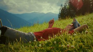 Man lying on a meadow for the outro shot in a sport Film Production